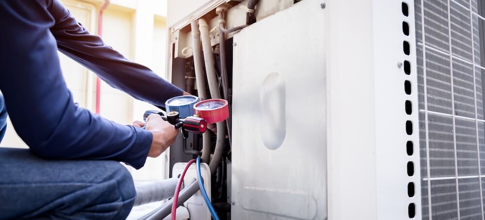 A technician works on fixing a broken HVAC system.